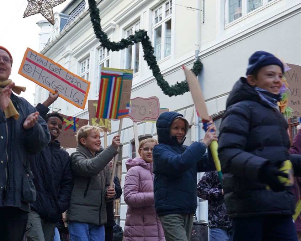 Børn går gennem gade med skilte og formidler deres budskaber.